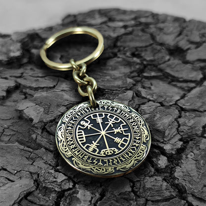 Macro photo of a brass coin keychain with deep-etched Vegvisir and protective antique patina, personalized nordic protection gift for travelers.