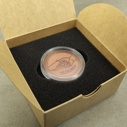 Custom copper coin for couples in a protective acrylic capsule and premium gift box with black foam insert, showcasing metal texture.