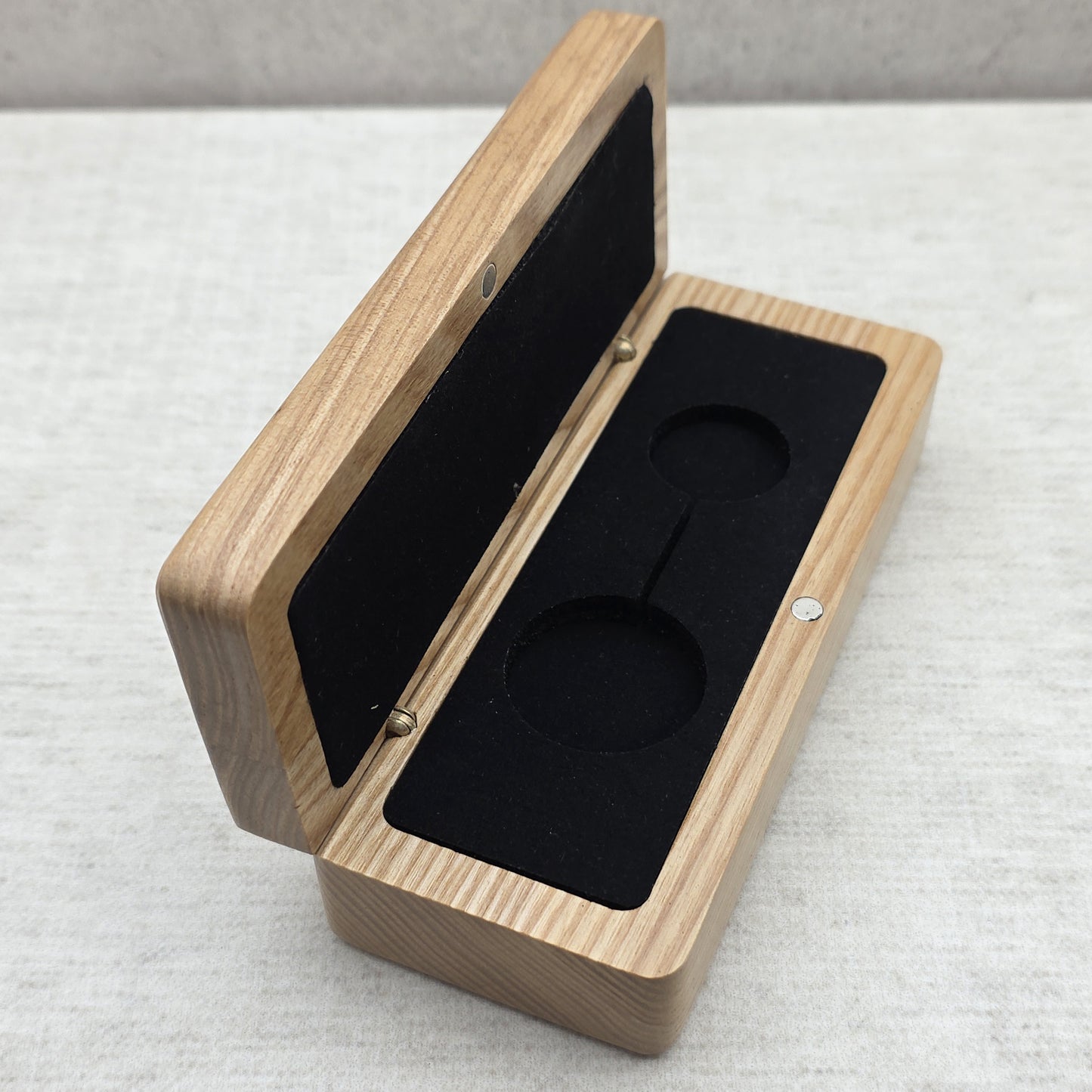 Handcrafted natural ash wood gift box open at an angle showing black velvet velvet insert with double cutout for keychain or pendant necklace