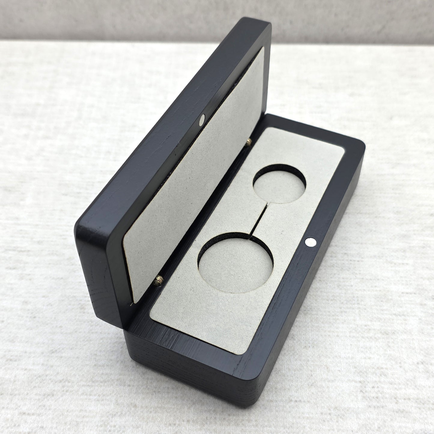 Handcrafted black ash wood gift box open at an angle showing light gray velvet insert with double cutout for keychain or pendant necklace