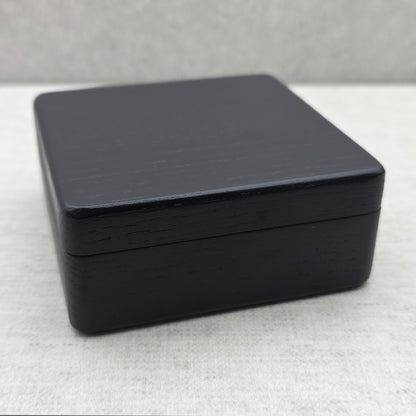 Front perspective of closed black wooden presentation box, compact storage case for collectable coins, jewelry pendants, and medals.