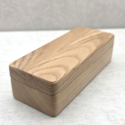 Closed solid ash wood display box side view showing natural wood grain texture and smooth rounded corners