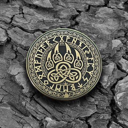 Viking brass coin Bear Paw on a natural dark texture background highlighting antique finish.