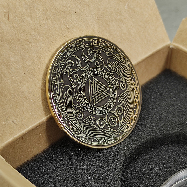 Perspective view of a 2mm thick brass challenge coin in a gift box, showcasing the metallic luster and intricate Viking design.