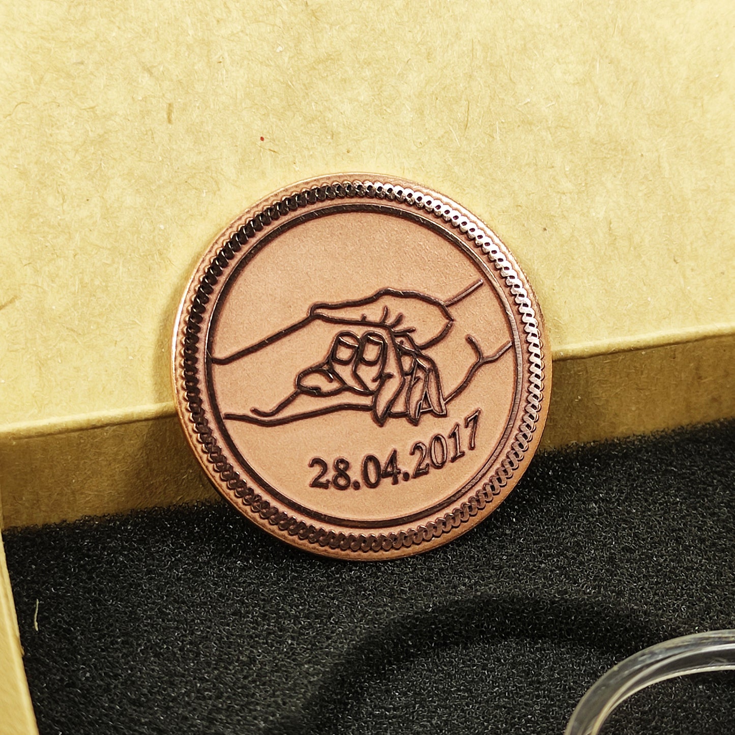 Detailed view of the copper personalized medal, highlighting the intricate hand-holding illustration and high-contrast dark patina engraving.
