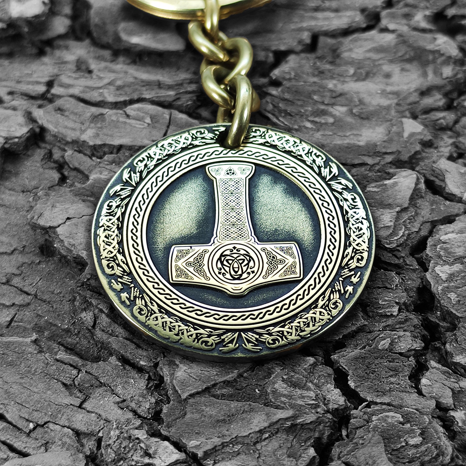 Macro photo of a brass coin keychain with deep-etched Mjolnir and protective antique patina, personalized nordic protection gift for viking fans.