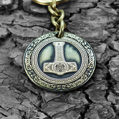 Macro photo of a brass coin keychain with deep-etched Mjolnir and protective antique patina, personalized nordic protection gift for viking fans.