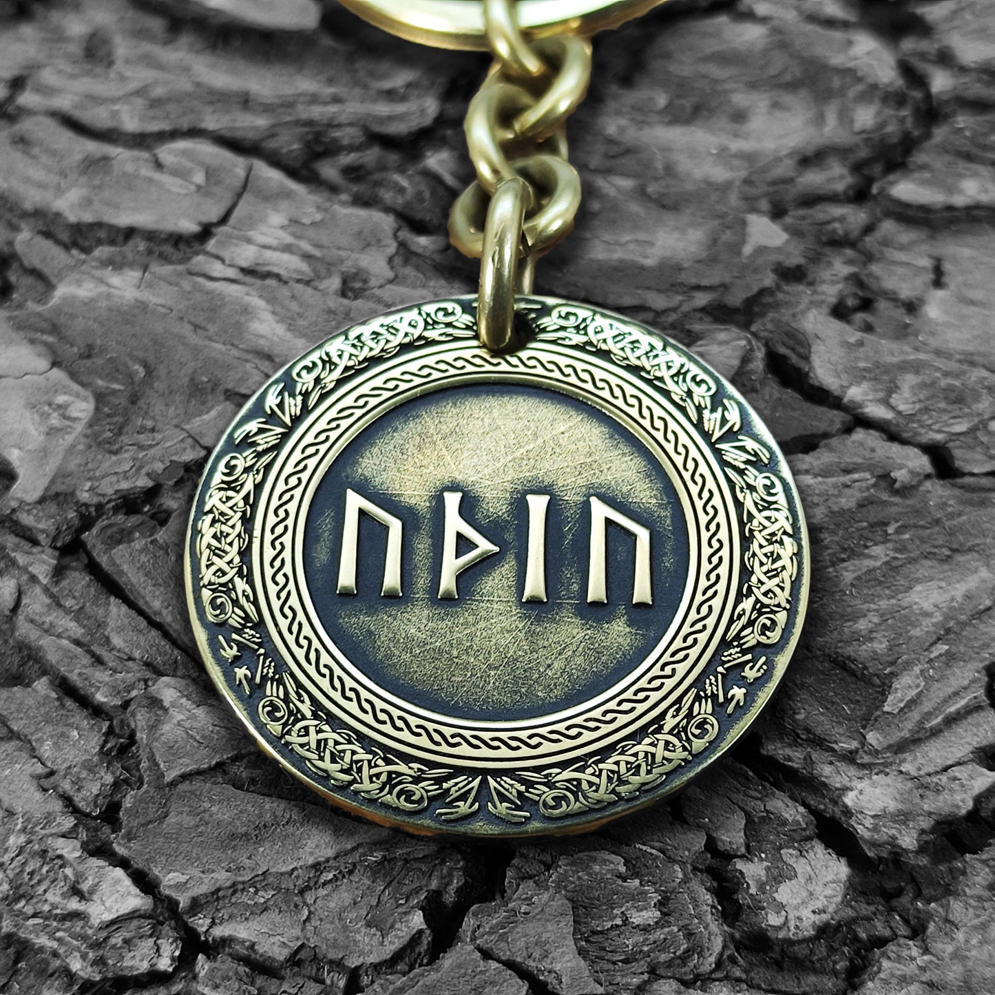 Macro photo of a brass coin keychain with deep-etched runes and protective antique patina, personalized gift for rune and mythology lovers.