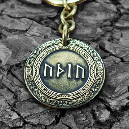 Macro photo of a brass coin keychain with deep-etched runes and protective antique patina, personalized gift for rune and mythology lovers.