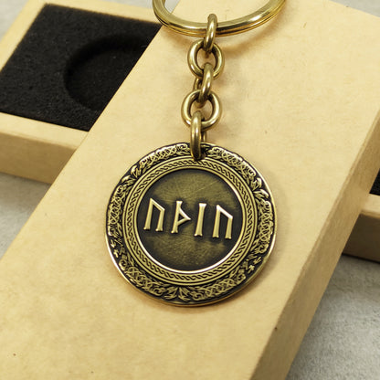 Detailed view of a brass rune coin with 3D-style engraving and dark recessed patina, featuring personalized Futhark or Veles symbols.