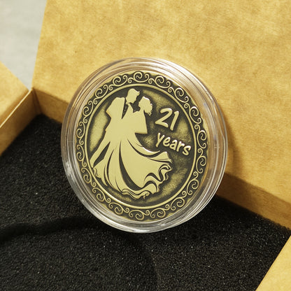 Customized 21st wedding anniversary brass coin presented in a clear acrylic case inside a premium gift box.