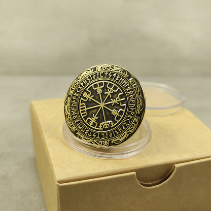 Angled view of the brass Viking compass coin showing deep laser engraving and relief.