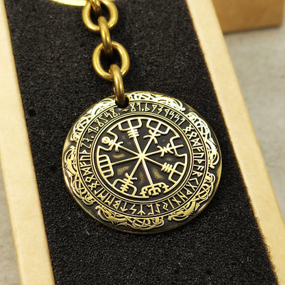 Detailed view of the brass Runic Compass coin, highlighting the intricate Vegvisir symbol and dark recessed patina engraving for high contrast.