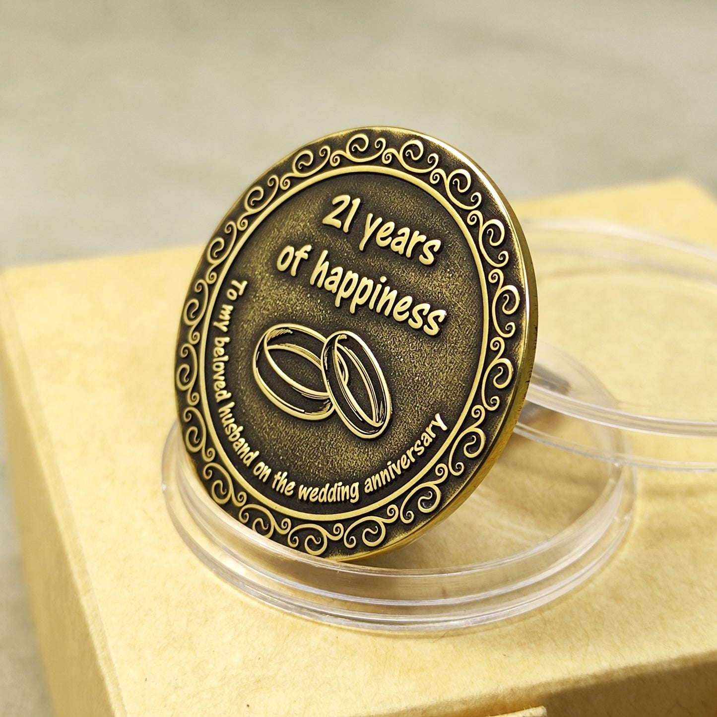 Close-up of the antique brass finish and deep relief engraving on a 21st anniversary gift coin, showing aged metal texture.