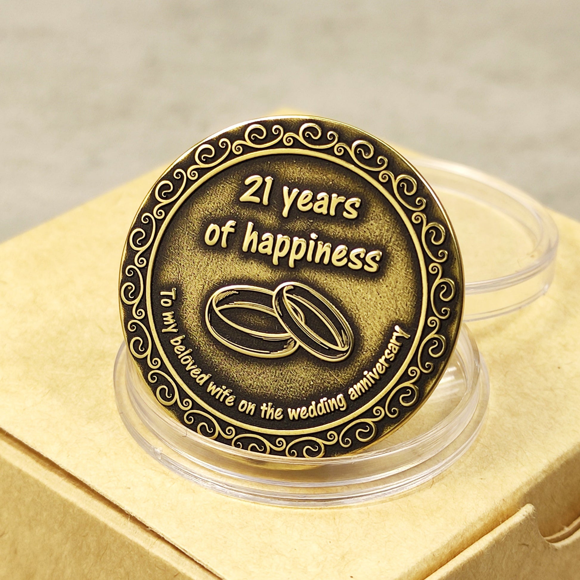 Reverse side of personalized brass wedding anniversary coin for wife with "21 years of happiness" engraving and vintage patina finish.