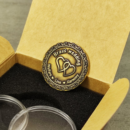 Custom brass wedding gift coin placed in a premium kraft paper gift box with black foam insert for 21st anniversary celebration.
