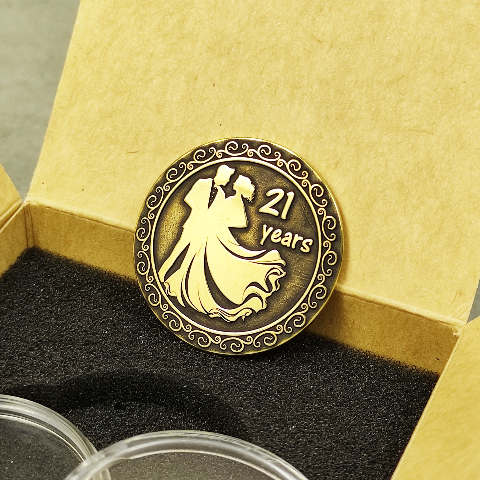 Obverse view of engraved brass anniversary coin for couple, 21 years celebration, featuring deep laser engraving.