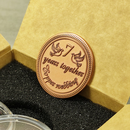 Engraved copper anniversary coin for 7 years of marriage celebration, personalized gift inside a craft paper box with foam insert, obverse view.