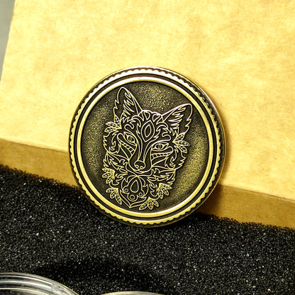 Detailed macro shot of an engraved brass coin with fox design, showing the high-quality metal finish and deep relief carving.