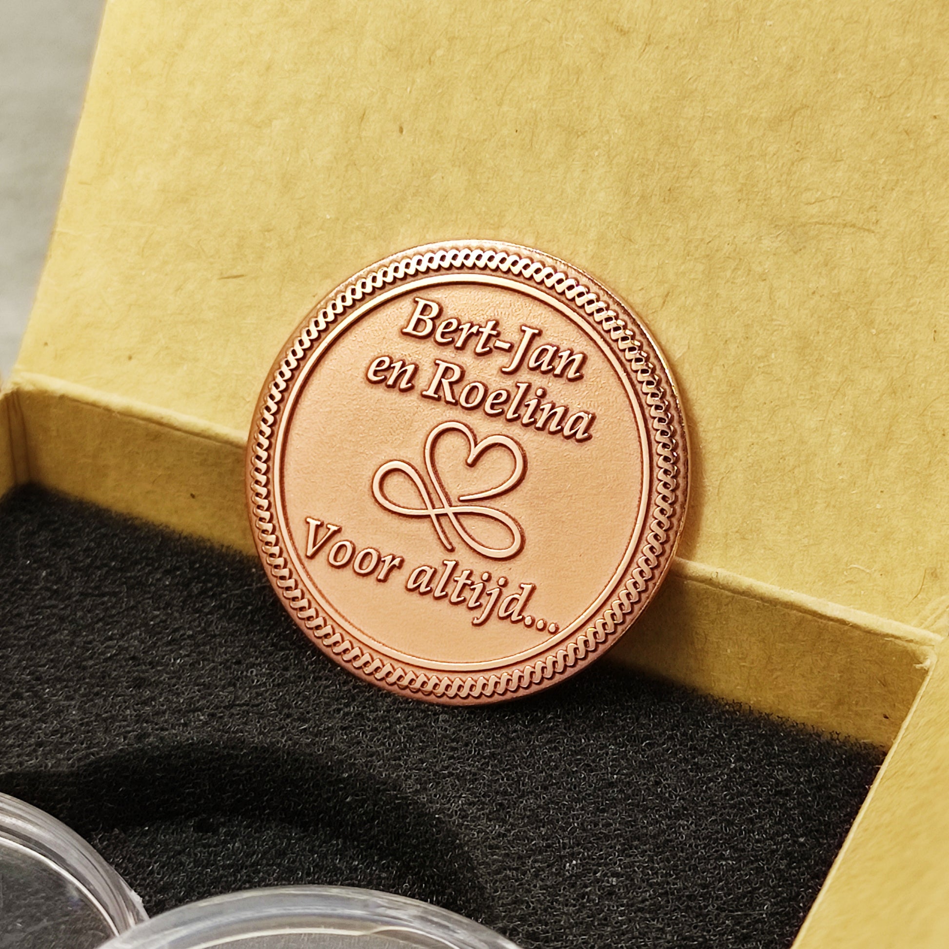 Personalized copper commemorative medal leaning against a gift box, highlighting the professional laser engraving on pure copper material.