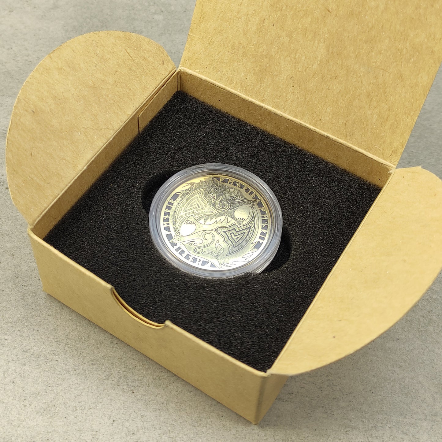 Personalized Fenrir brass coin in a protective acrylic capsule and craft box, premium presentation of a handcrafted Viking gift.