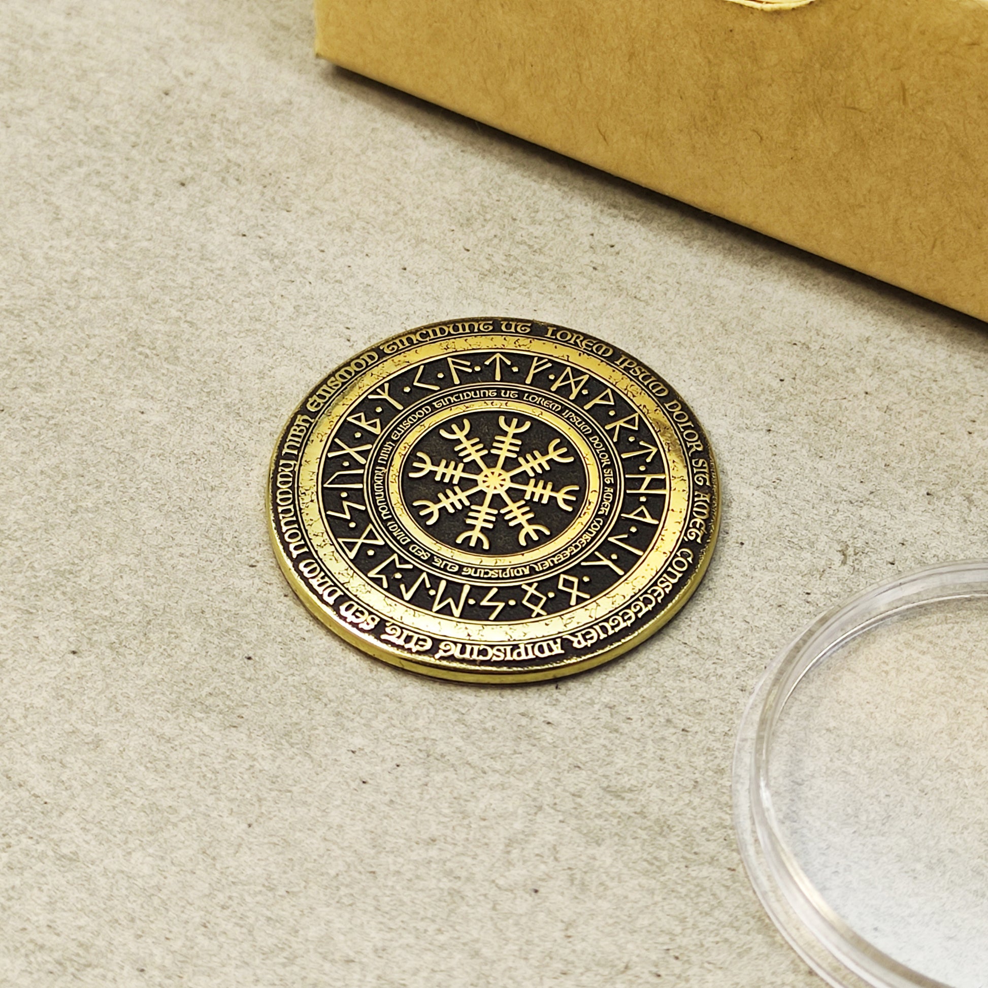 Top view of a brass Nordic challenge coin featuring Vegvisir and Elder Futhark runes engraving.