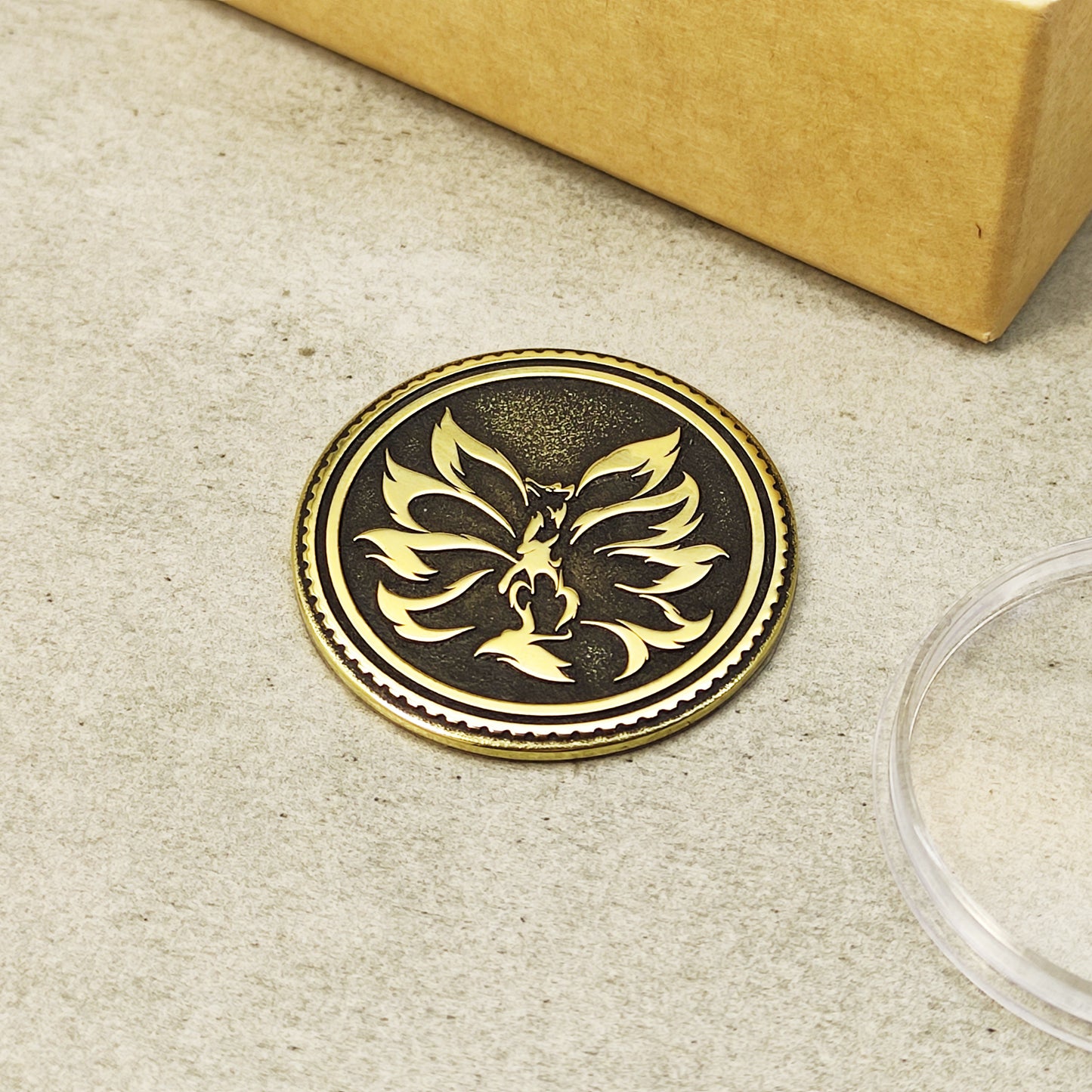 Top view of a handcrafted brass Kitsune medallion with mythical fox symbol, featuring high-contrast blackened background.