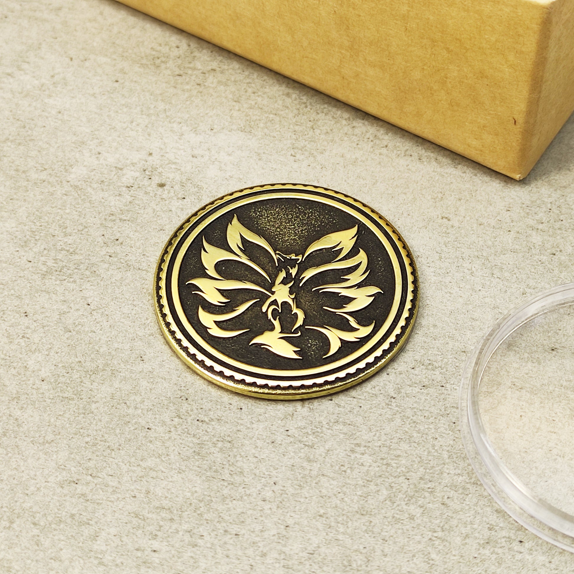 Top view of a handcrafted brass Kitsune medallion with mythical fox symbol, featuring high-contrast blackened background.
