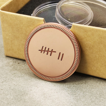 Personalized copper anniversary gift for husband, "7 years" tally mark coin leaning on a craft paper gift box.