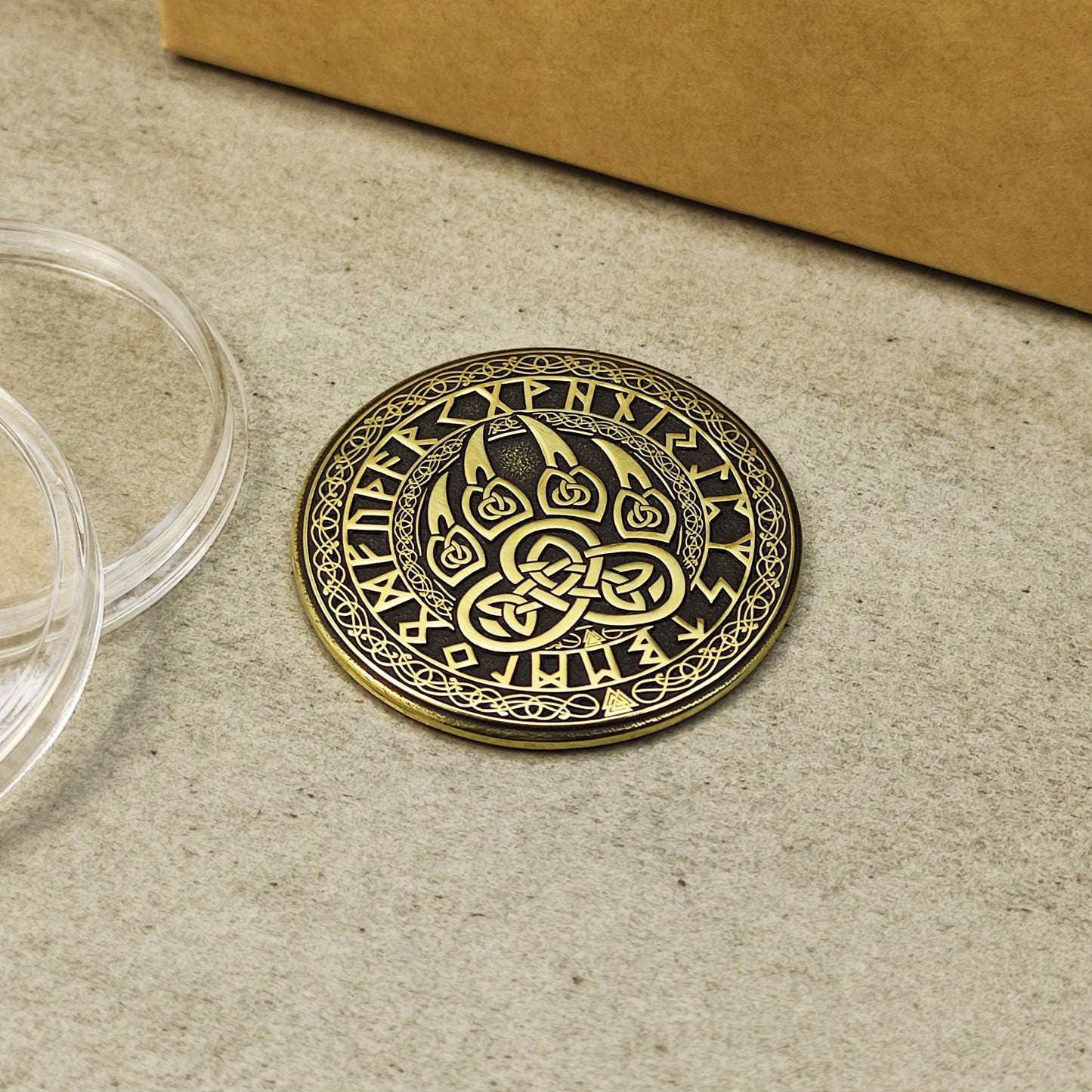 Close-up of the Scandinavian brass talisman with intricate runic circle and bear claw design.