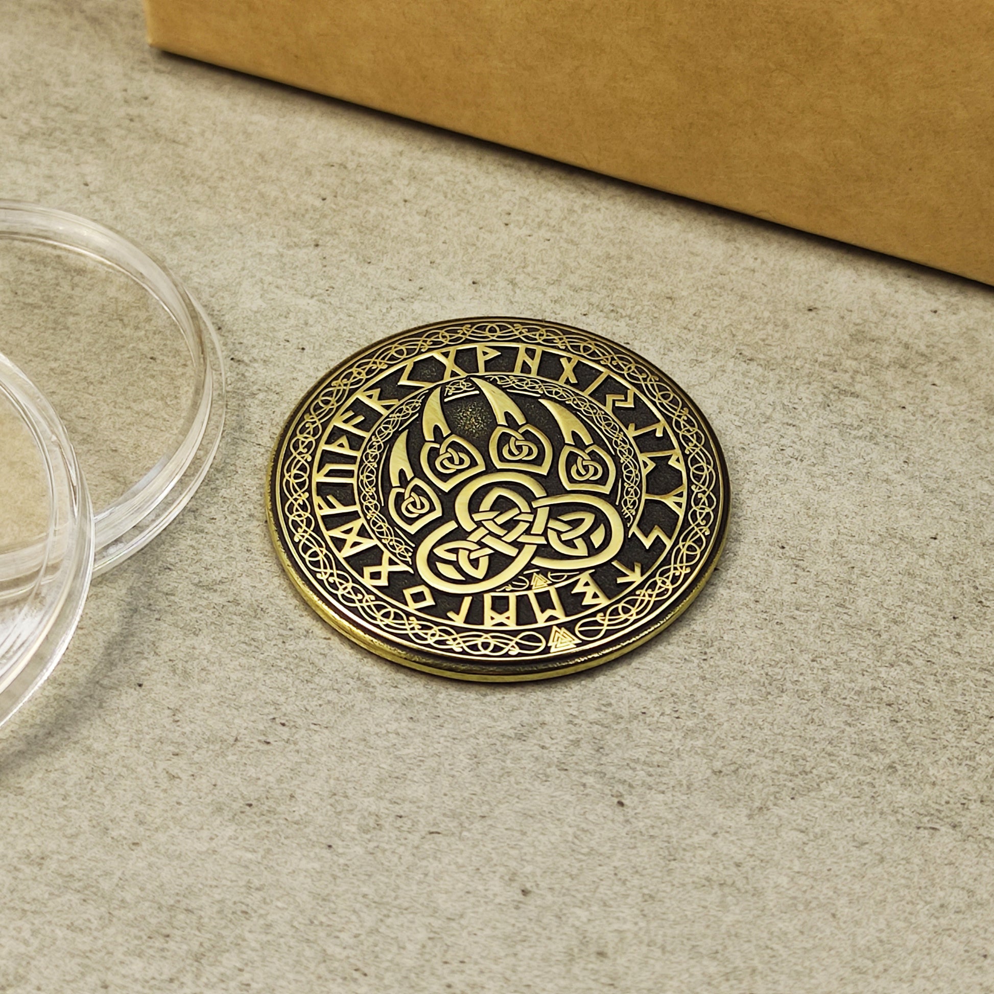 Close-up of the Scandinavian brass talisman with intricate runic circle and bear claw design.