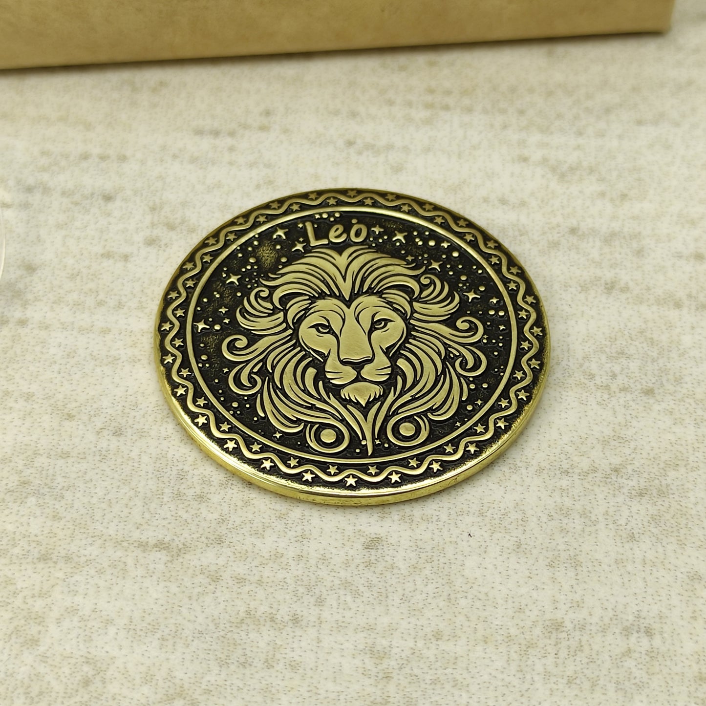 Detailed view of the Leo zodiac brass medal, highlighting the intricate 3D-style engraving and dark recessed patina on the polished brass surface.