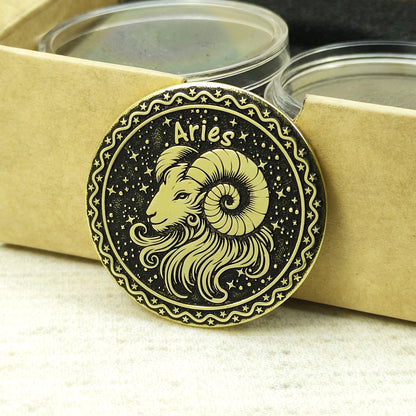 Aries zodiac brass medal leaning against a craft gift box, highlighting the antique gold-tone material and precision laser-etched details.
