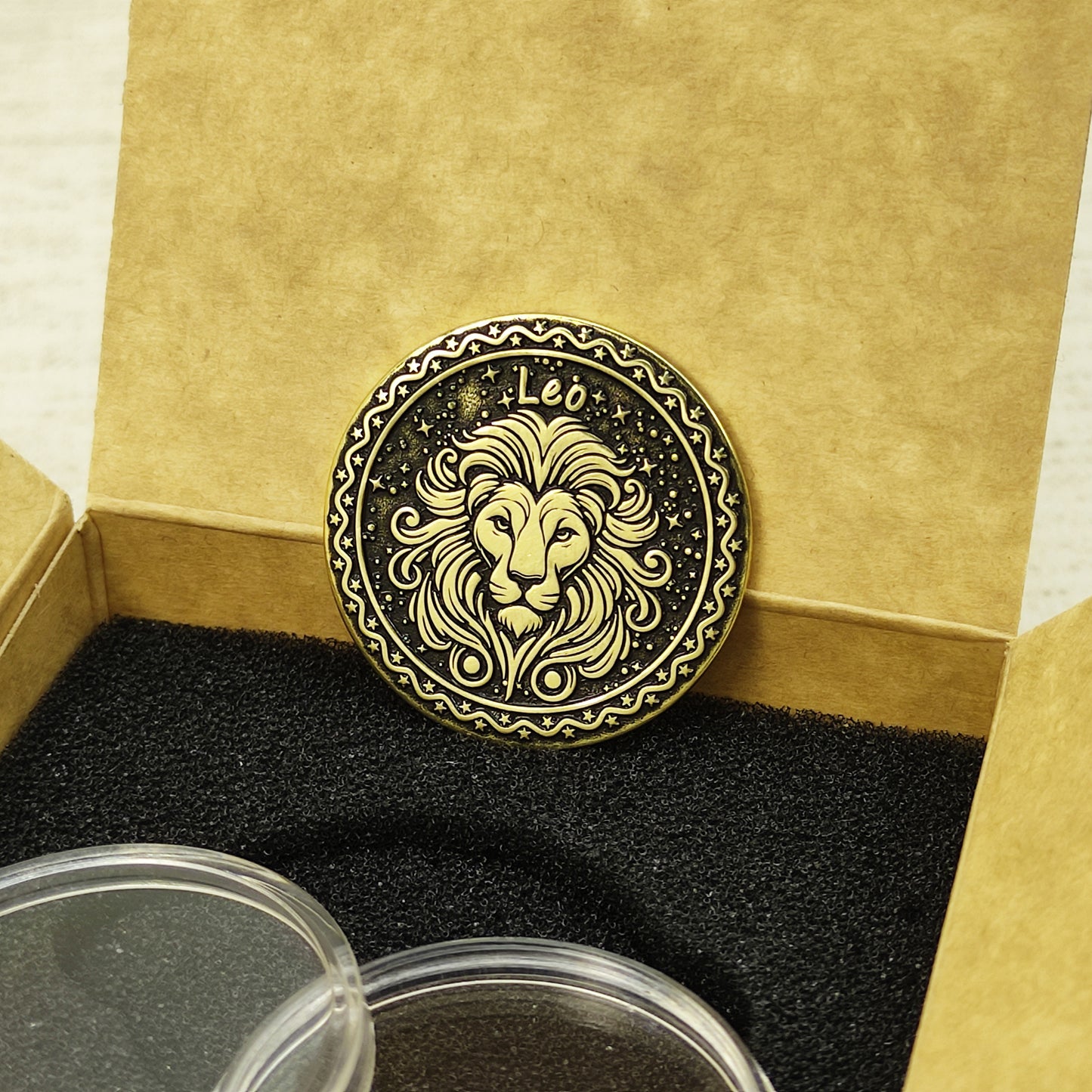 Custom Leo zodiac brass coin in a premium gift box with black foam insert, highlighting the gold-tone brass material and dark engraved details.