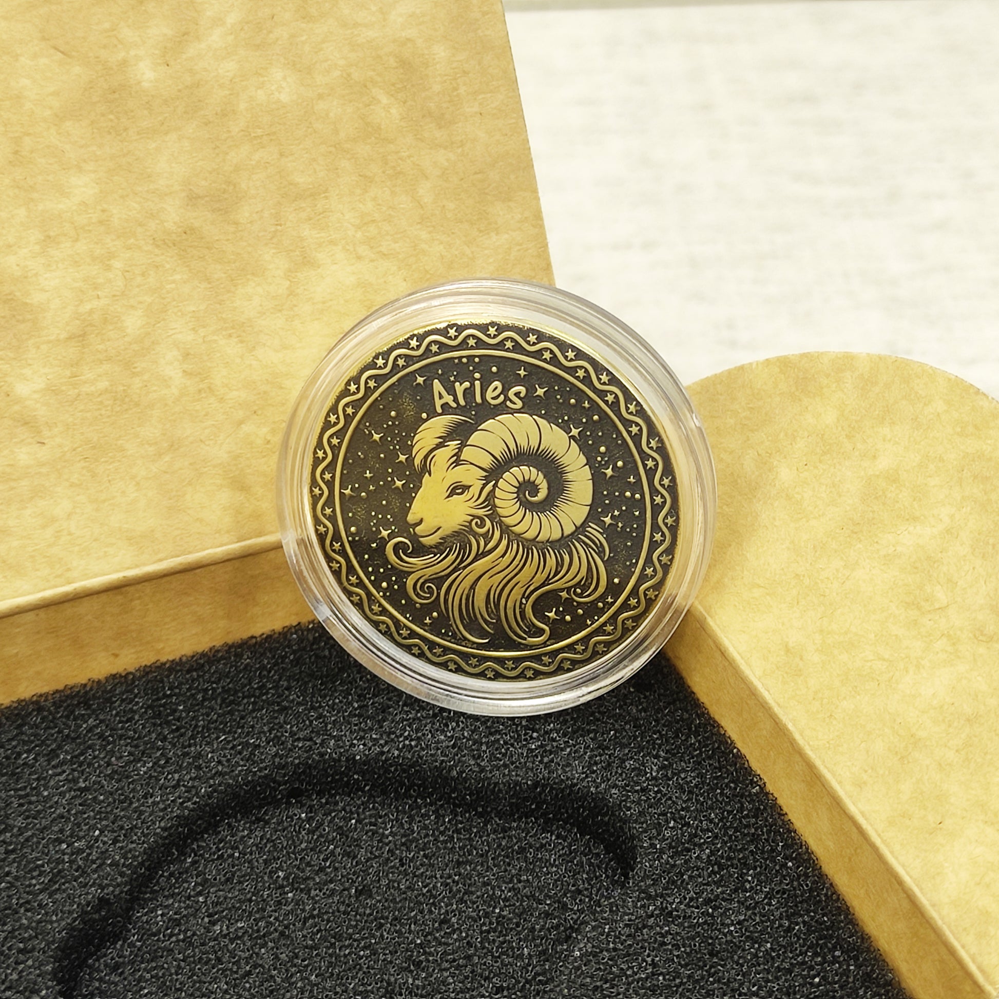 Top view of the Aries zodiac medal in a protective acrylic capsule, handcrafted brass coin gift for astrology lovers with personalized laser etching.