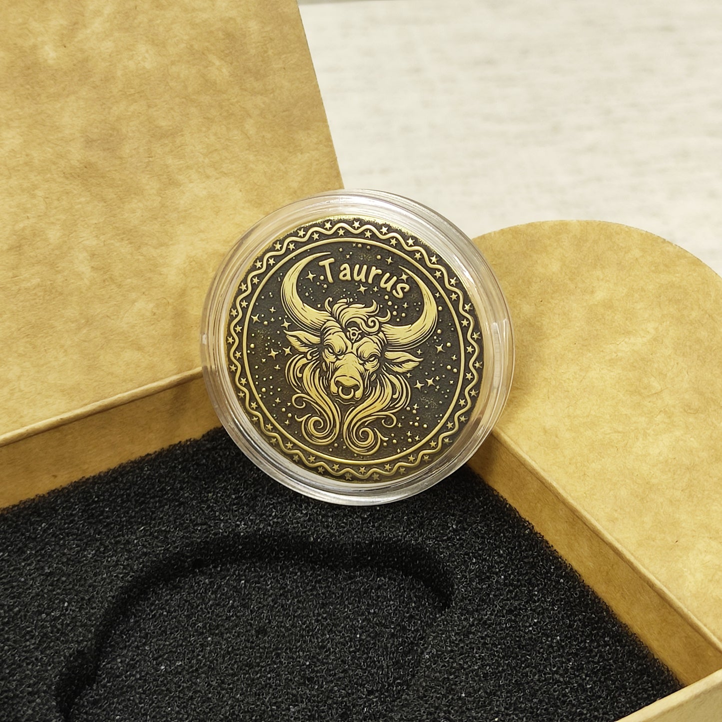 Top view of the Taurus zodiac medal in a protective acrylic capsule, handcrafted brass coin gift for astrology lovers with personalized laser etching.