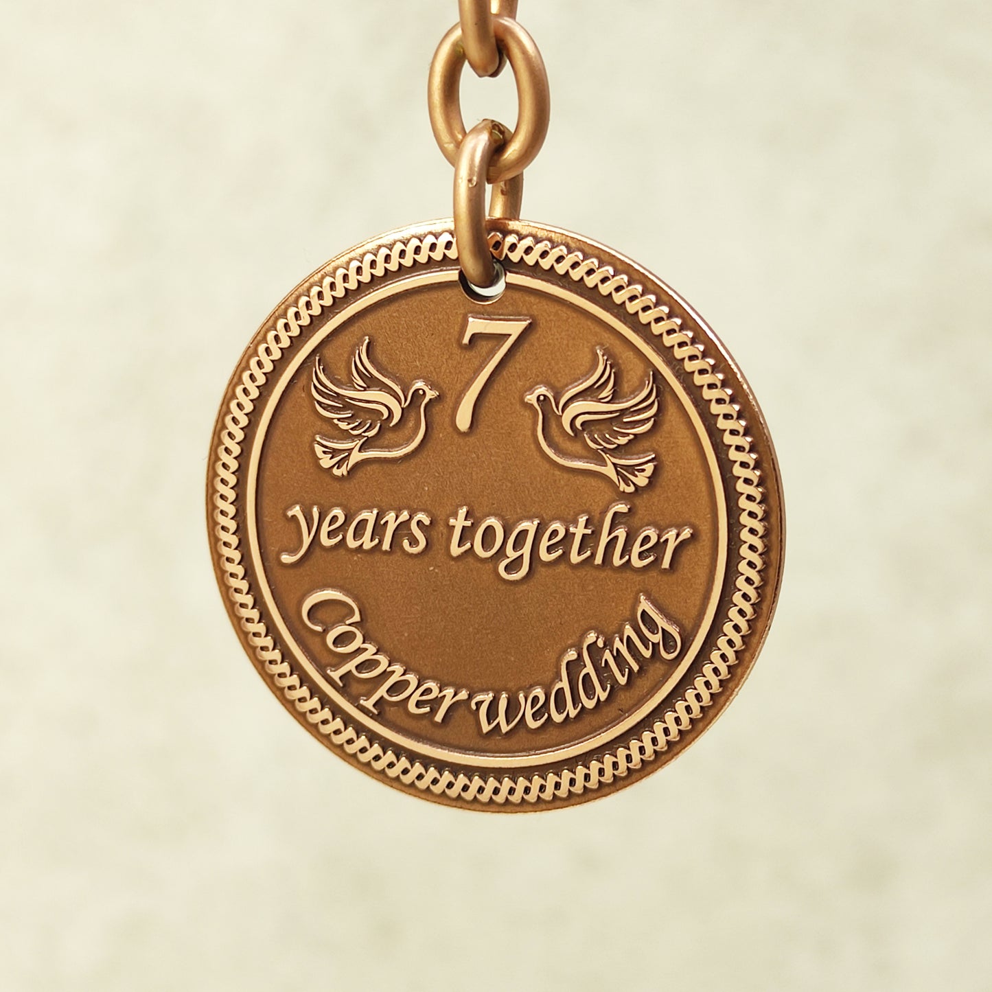 Close-up of handcrafted copper coin pendant for 7 years together with ornate borders and vintage patina.