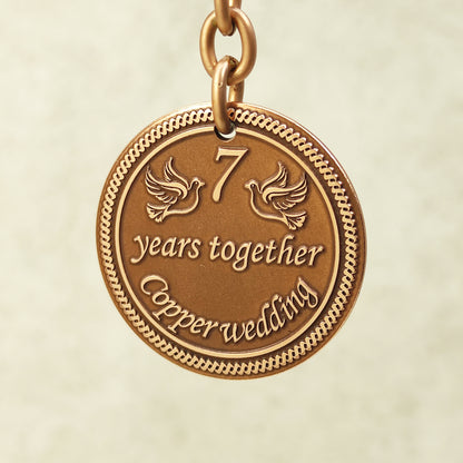 Close-up of handcrafted copper coin pendant for 7 years together with ornate borders and vintage patina.