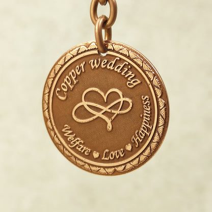 Close-up of handcrafted copper anniversary coin pendant featuring intricate infinity symbol and vintage patina.