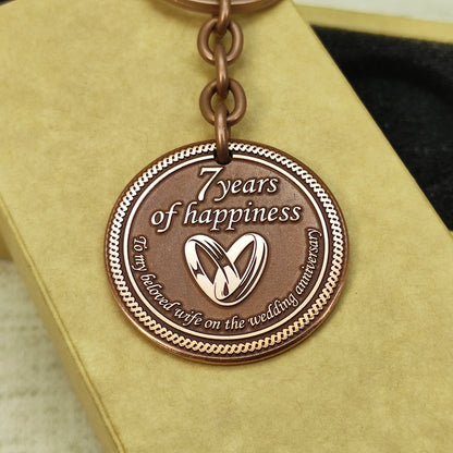 Engraved copper keychain coin for 7 years of marriage celebration, personalized gift with sturdy metal ring and antique finish.