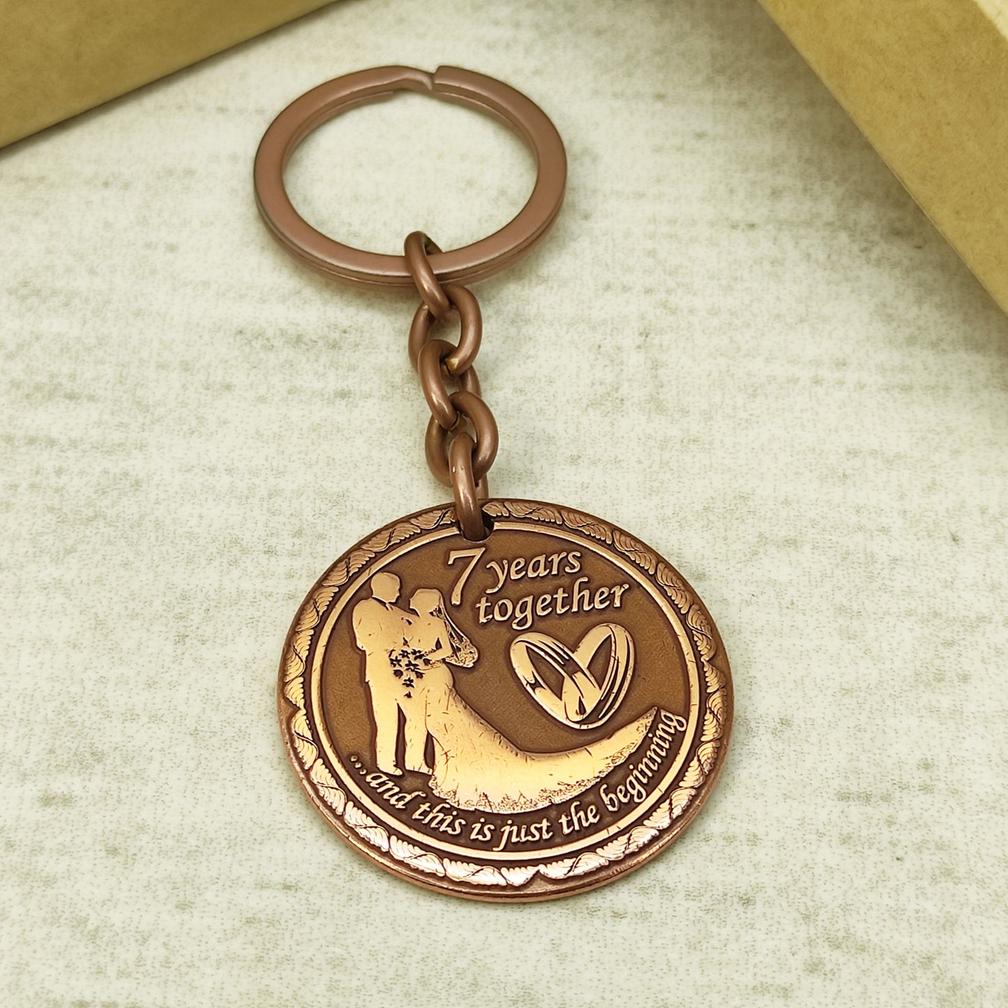 Engraved copper keychain coin for 7 years of marriage celebration, personalized wedding gift with sturdy metal ring and chain.