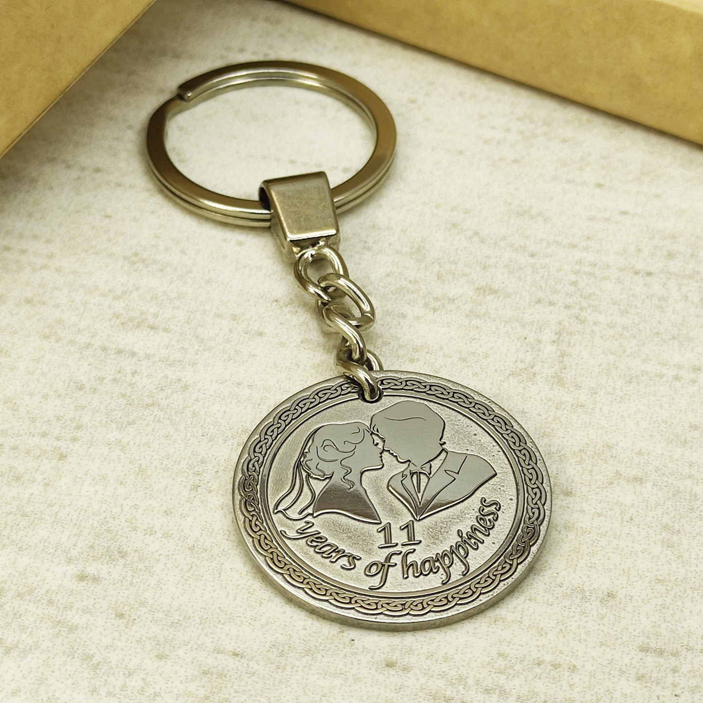 Stainless steel keychain with engraved anniversary coin, showing the sturdy metal ring and chain link attachment, polished finish for steel anniversary gift.