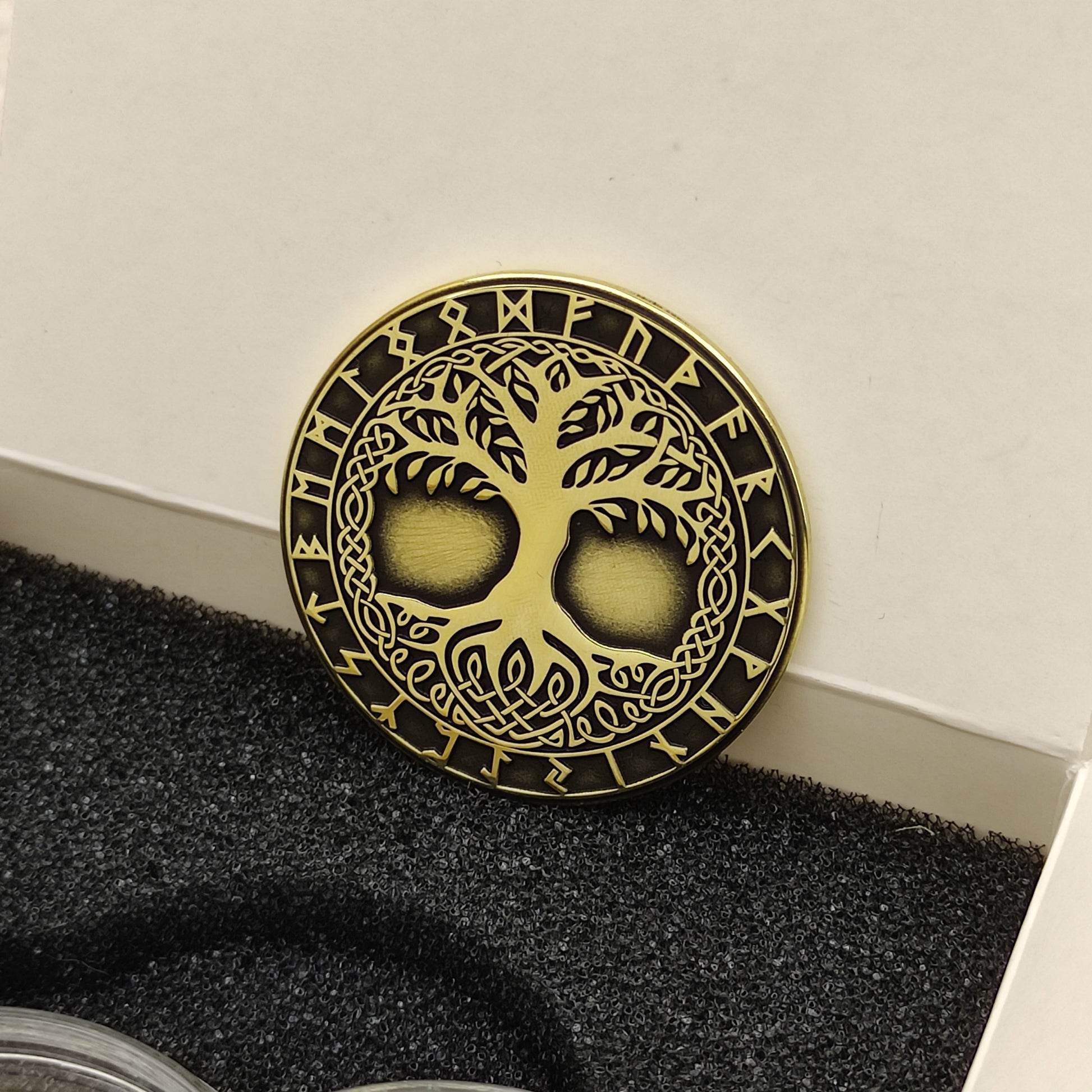 Perspective view of a 2mm thick brass challenge coin, showcasing the metallic luster and high-contrast Viking symbolism.