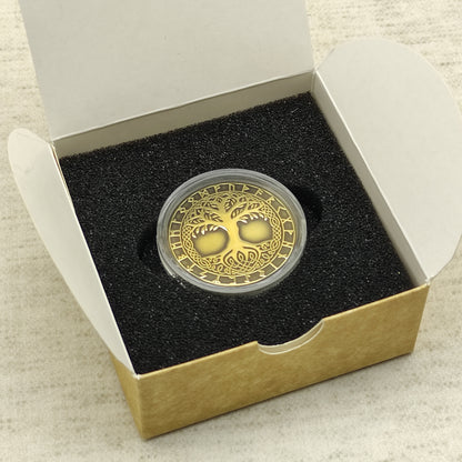 Custom engraved brass Yggdrasil coin in a gift box with foam insert, professional presentation of a personalized Norse talisman.