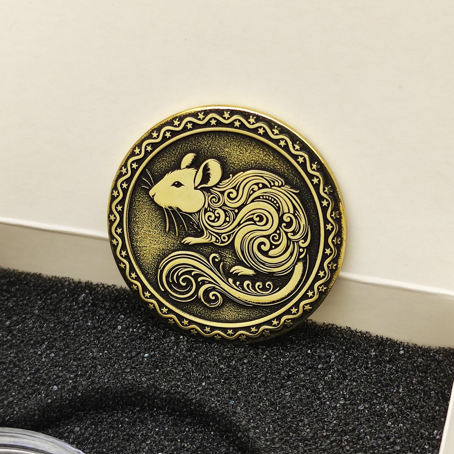 Vertical view of the personalized brass zodiac medal in a premium black insert box, showcasing the antique finish and engraved star border.