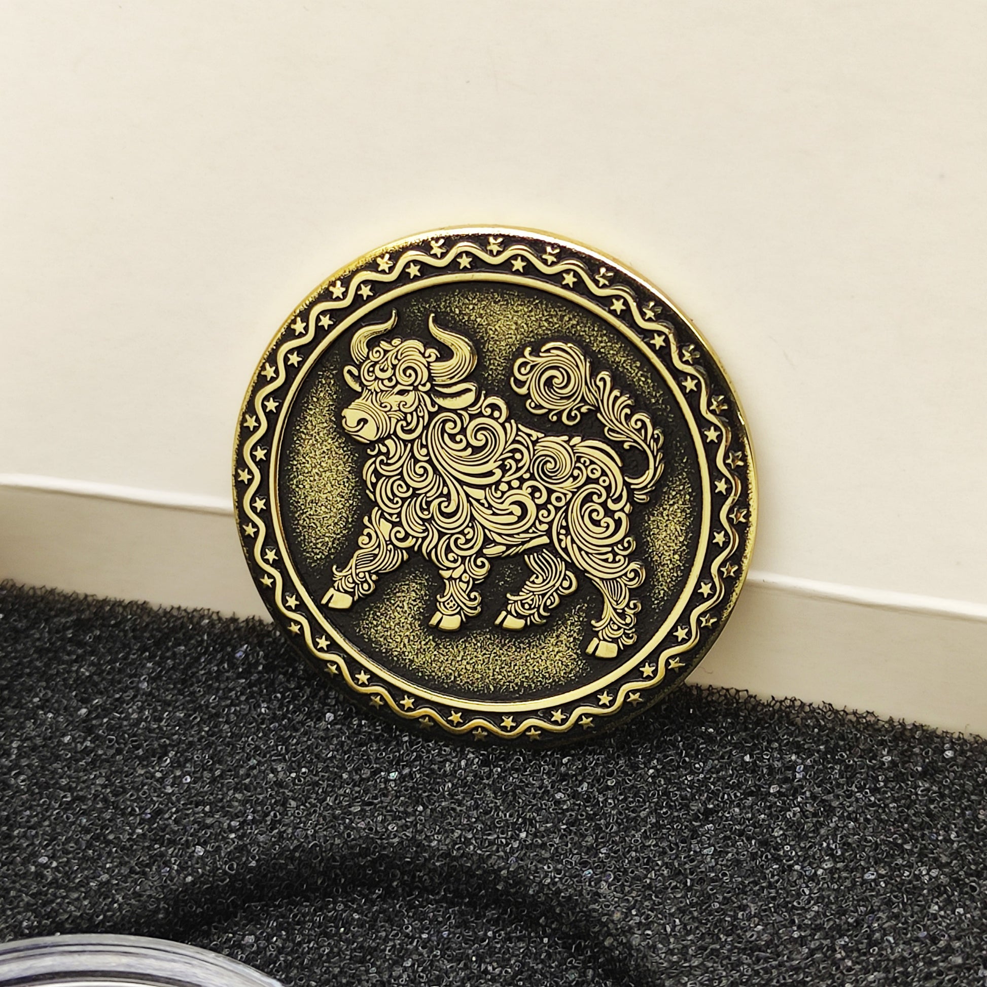 Vertical view of the personalized brass zodiac medal in a premium black insert box, showcasing the antique finish and engraved ornamental border.