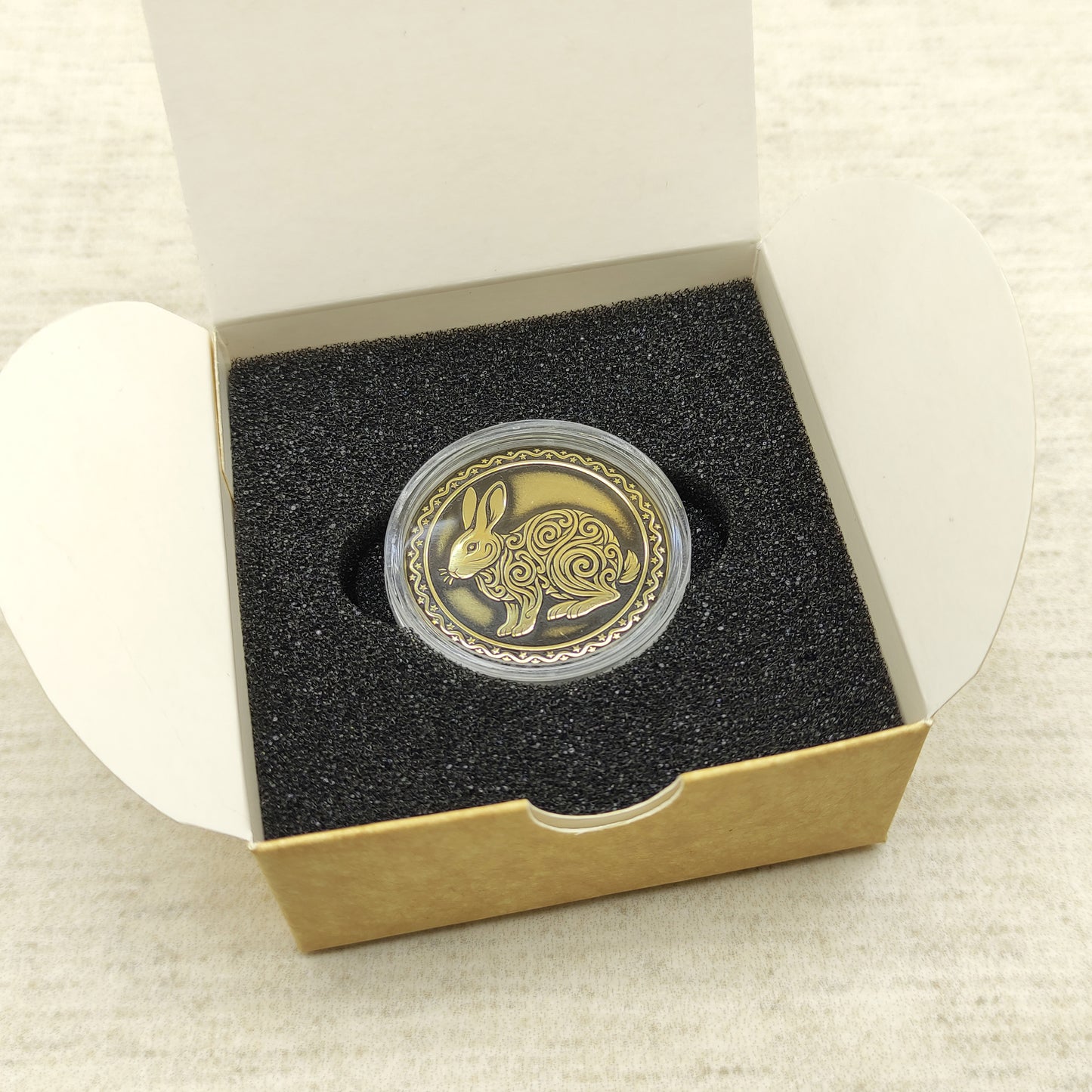 Ready-to-gift personalized brass zodiac medal, handmade Chinese Year of the Rabbit coin in a square craft box with black foam insert.