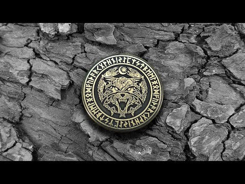 Norse mythology Fenrir Wolf brass amulet, detailed runic circle engraving with antique finish on a stone background.