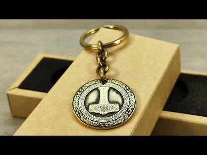 Video showcase of a personalized brass Mjolnir keychain, highlighting the metallic gold-tone texture and high-contrast professional patina.
