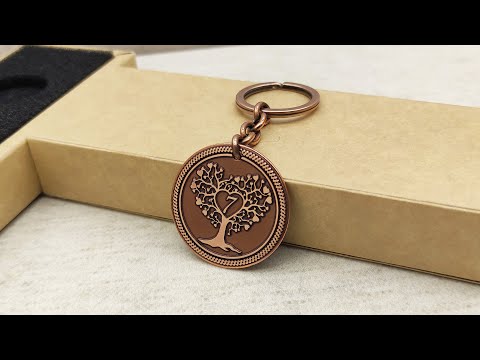 Side view of personalized copper anniversary coin keychain showing metal thickness and vintage oxidized texture on a gift box.